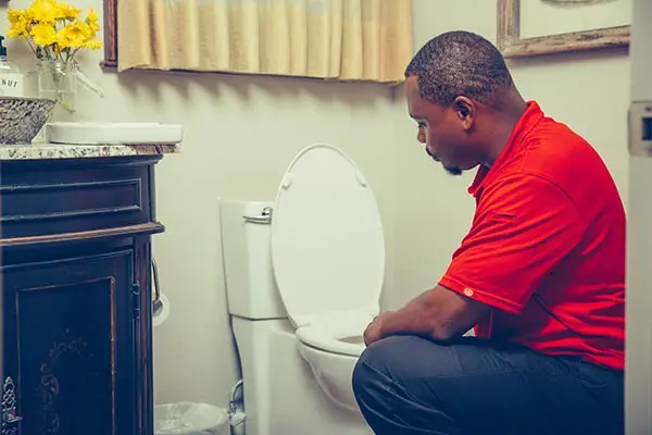 Houston emergency plumber fixing overflowing toilet with sewage backup