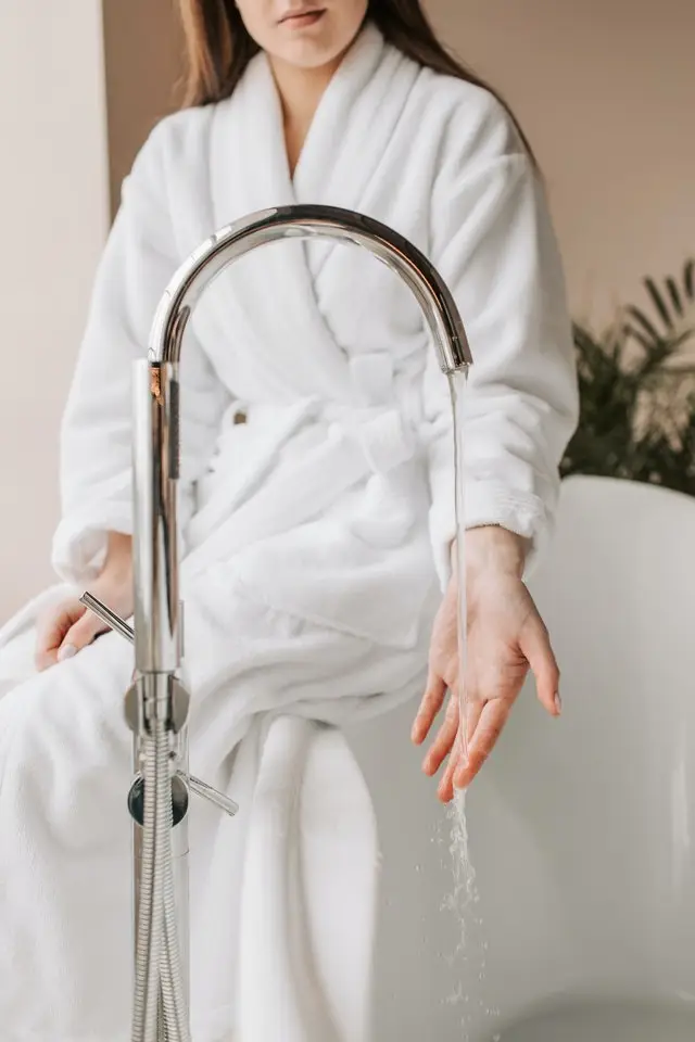 woman checking water temperature for bath needs Houston water heater repair