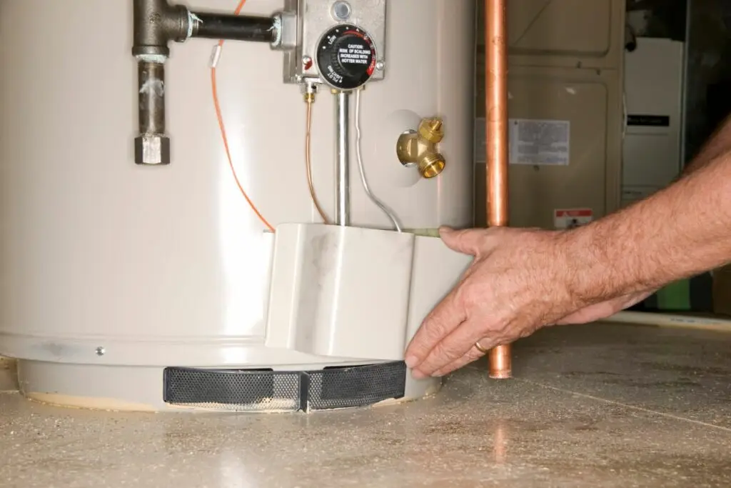 Plumber placing cover plate on water heater during Houston water heater installation