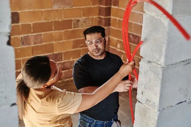 Plumbers holding red PEX pipes for Houston plumbing repairs