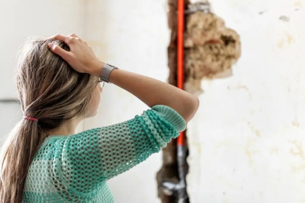 Person staring at pipe that needs Houston plumbing leak repairs
