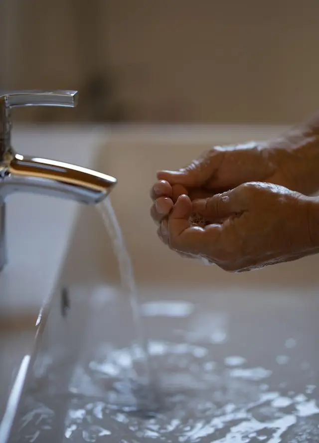 Person using clogged sink that needs repair from a Houston commercial plumber