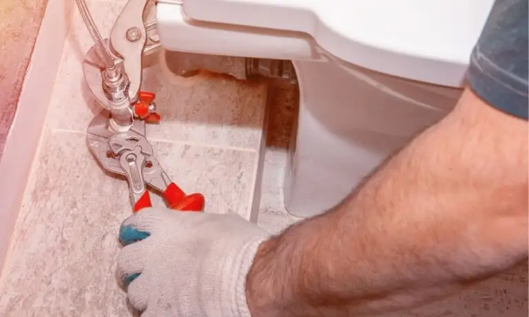technician from Houston best plumbers tightening toilet valve